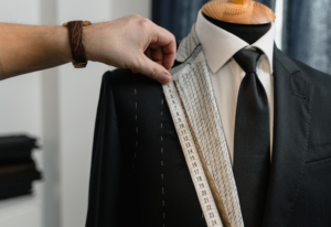 Tailor measuring luxury suit jacket — choosing the right dry cleaner ensures perfect fit and expert garment care.